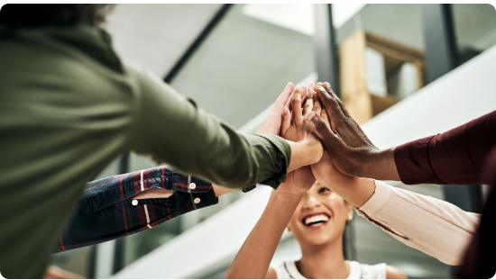 Colleagues joining hands in a team celebration, representing the vision of InHouse Physicians.
