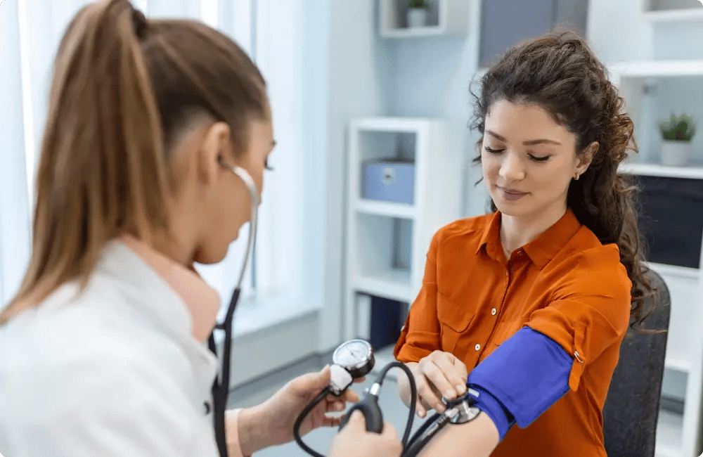 Nurse checking an employee's blood pressure at an on-site workplace clinic for InHouse Physicians.